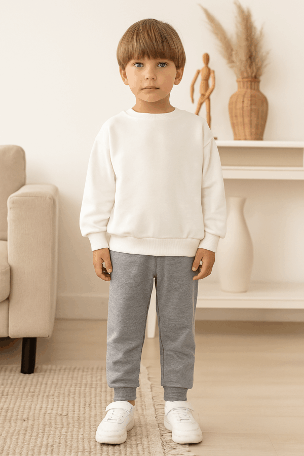 Aγόρι με άσπρη μπλούζα και παντελόνι φόρμα γκρι