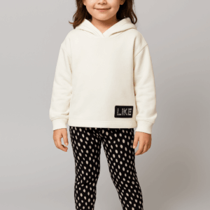 Κορίτσι με σετ φόρμες σε άσπρο φούτερ με κουκούλα και κολάν με μαύρο τύπου πουά